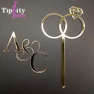 Acrylic engagement cake charm with couple's monograms and topper with engagement rings set